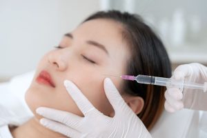 Asian woman reaching a Plinest injectable treatment